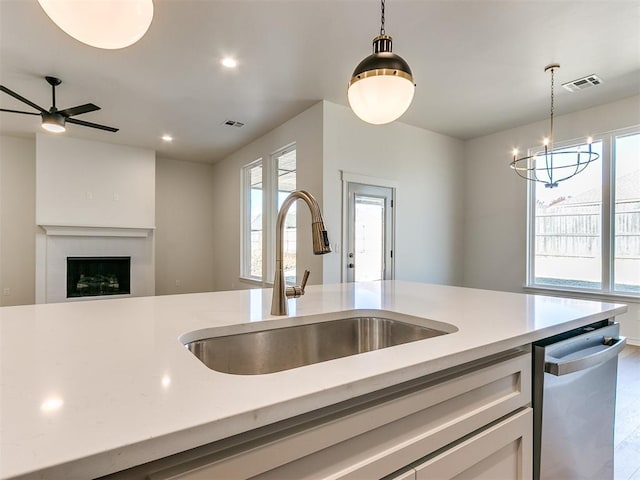 kitchen with dishwasher, wood-type flooring, decorative light fixtures, and sink