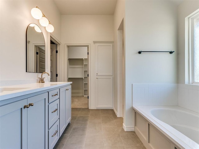 bathroom with plenty of natural light, a bath, and vanity