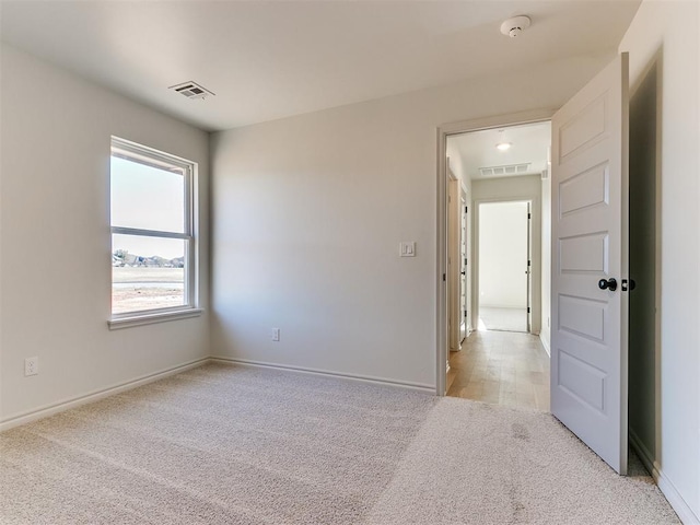 spare room featuring light carpet