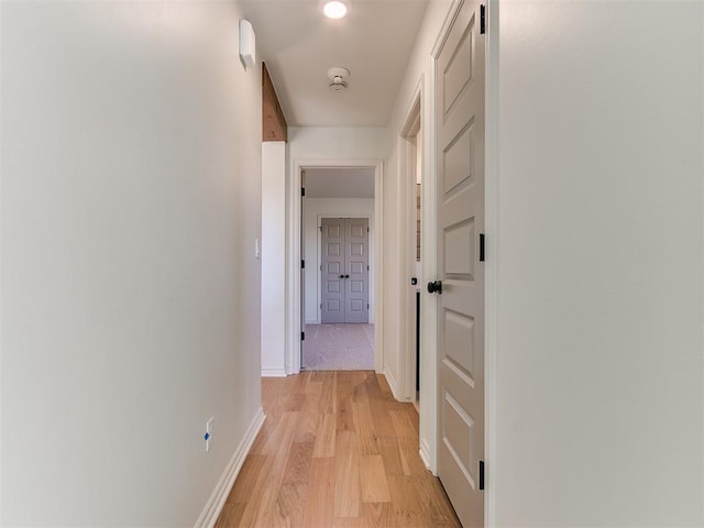 corridor with light hardwood / wood-style floors