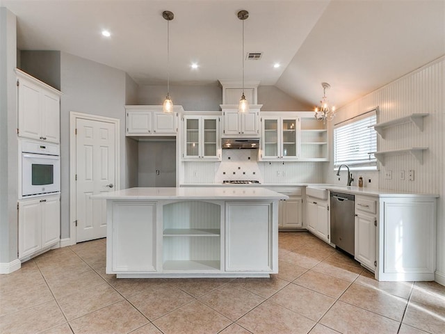 kitchen with a kitchen island, stainless steel dishwasher, oven, pendant lighting, and white cabinets