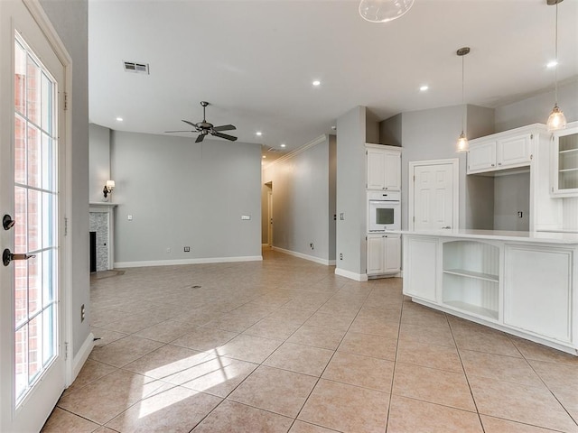 unfurnished living room with ceiling fan, light tile patterned flooring, plenty of natural light, and crown molding