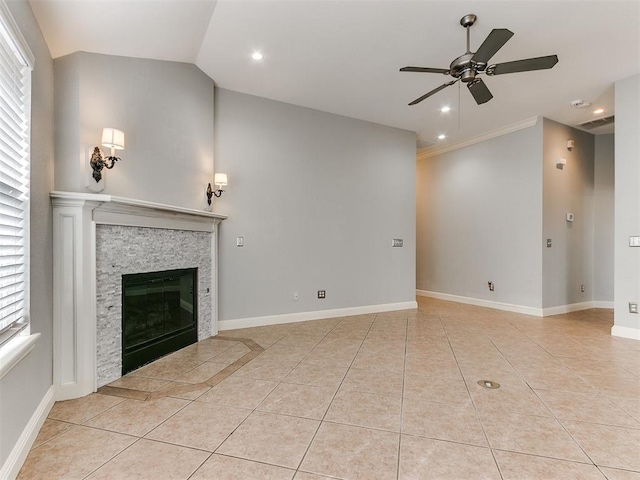 unfurnished living room with a stone fireplace, a wealth of natural light, lofted ceiling, and ceiling fan