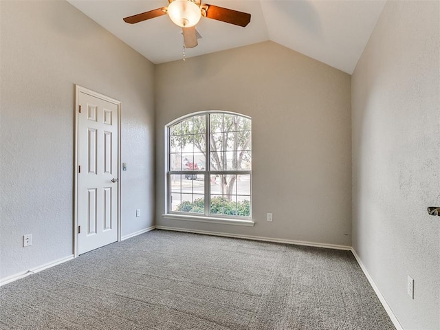 carpeted spare room featuring vaulted ceiling and ceiling fan