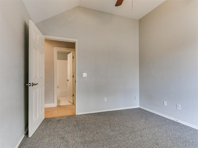 carpeted spare room featuring ceiling fan and lofted ceiling