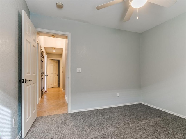 spare room with ceiling fan and light colored carpet