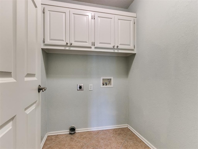 clothes washing area with cabinets, light tile patterned floors, washer hookup, and hookup for an electric dryer