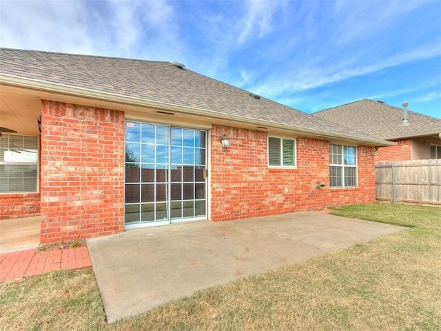 rear view of house featuring a lawn and a patio