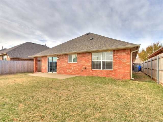 rear view of property with cooling unit, a patio area, and a yard