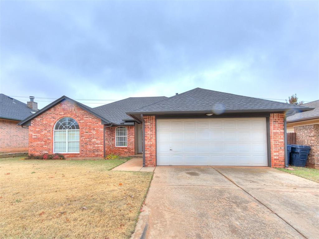 single story home featuring a garage and a front lawn