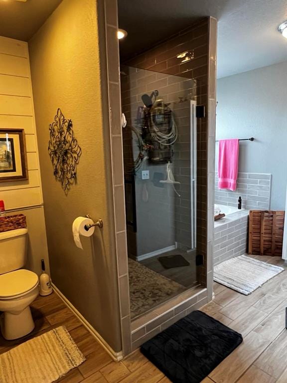 bathroom with toilet, wood-type flooring, and independent shower and bath