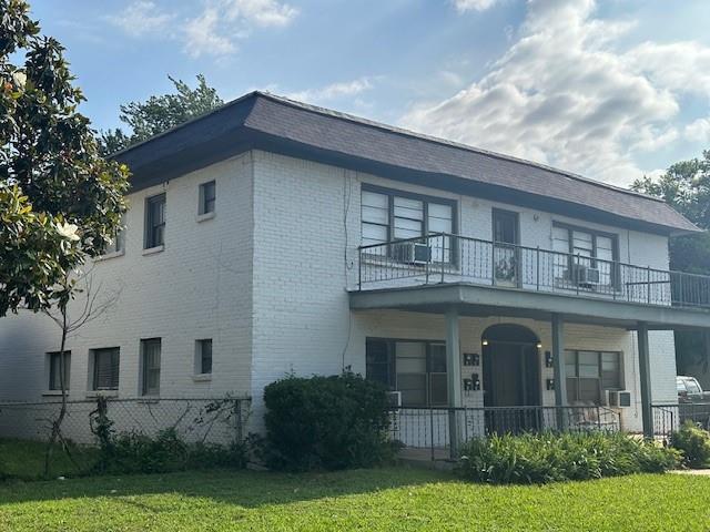 view of front of home with a balcony, a front lawn, and covered porch