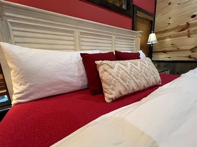 bedroom featuring wooden walls