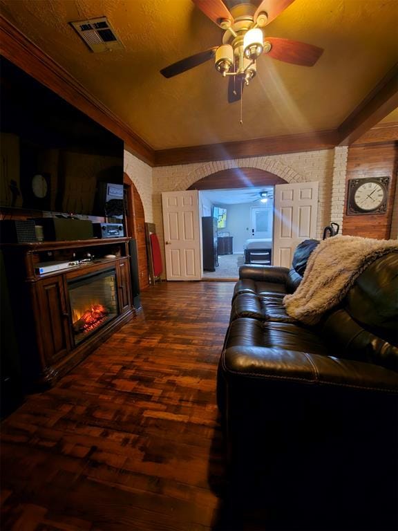 home theater with ceiling fan, dark hardwood / wood-style flooring, and ornamental molding