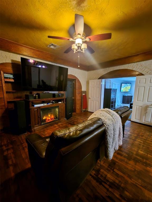 living room with ceiling fan, dark hardwood / wood-style floors, and a textured ceiling