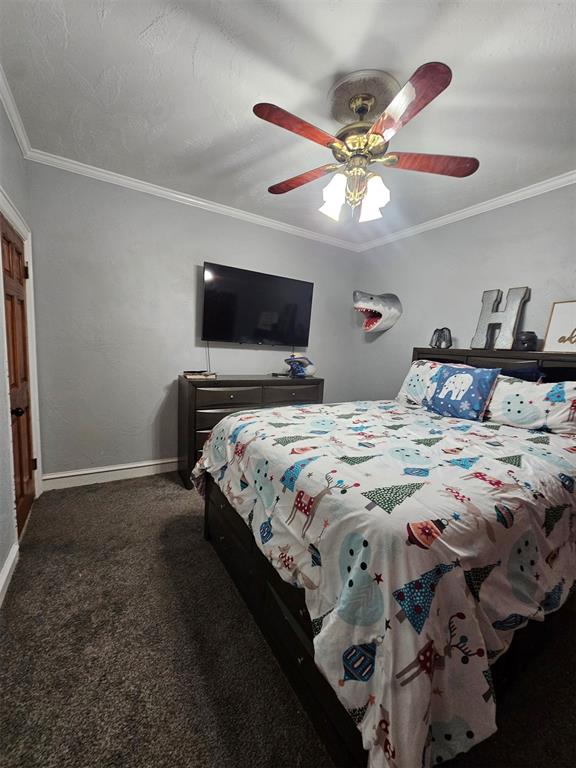 carpeted bedroom with ceiling fan and ornamental molding