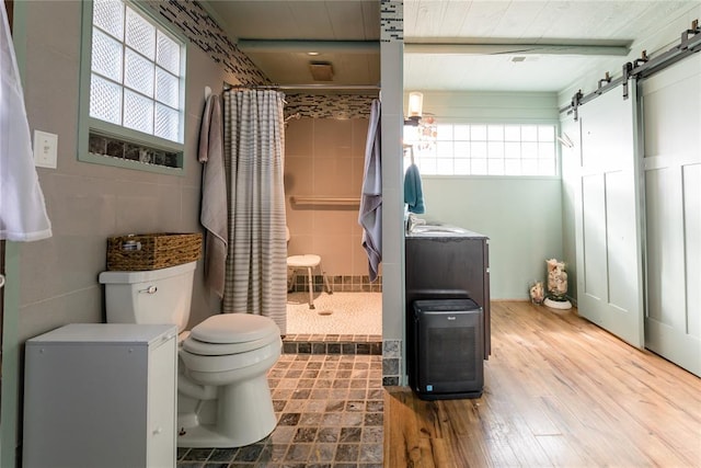 full bathroom featuring beam ceiling, a shower stall, toilet, and wood finished floors