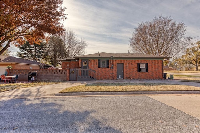 ranch-style house featuring a fenced front yard and brick siding