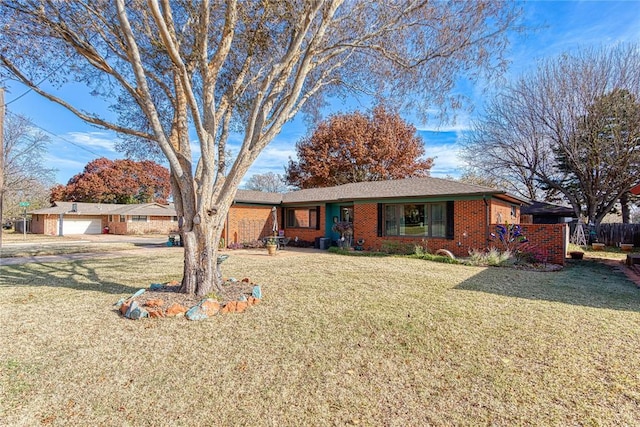 single story home with a garage, a front yard, brick siding, and fence