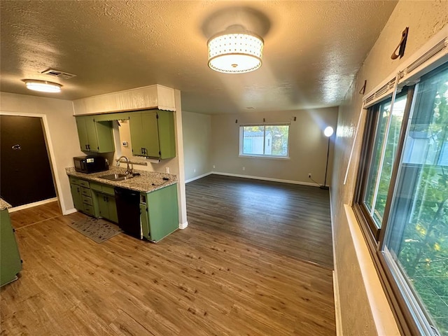 kitchen featuring a textured ceiling, dark hardwood / wood-style flooring, green cabinets, and black appliances