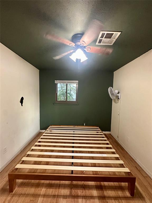 unfurnished bedroom featuring ceiling fan and wood-type flooring