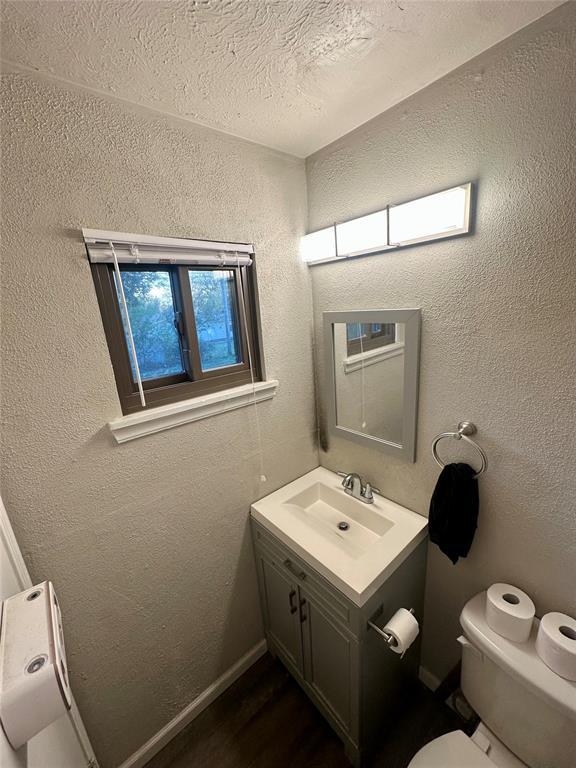 bathroom with vanity, toilet, and a textured ceiling