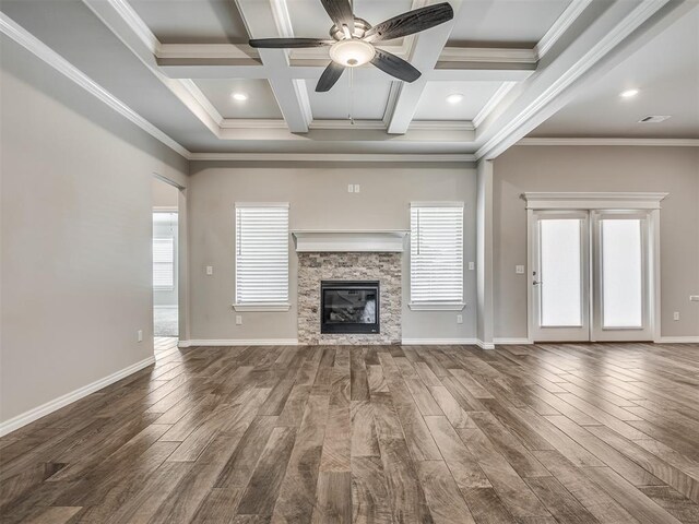 unfurnished living room with ornamental molding, a stone fireplace, dark wood-type flooring, and coffered ceiling