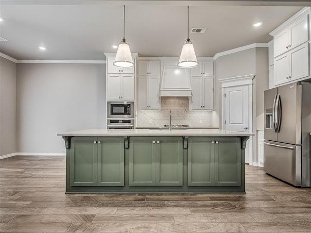 kitchen with white cabinetry, a center island with sink, pendant lighting, and appliances with stainless steel finishes