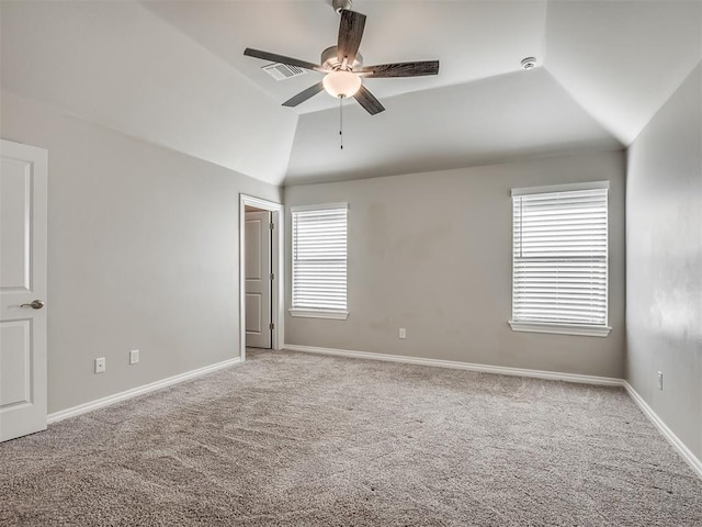 carpeted spare room with a healthy amount of sunlight, ceiling fan, and lofted ceiling