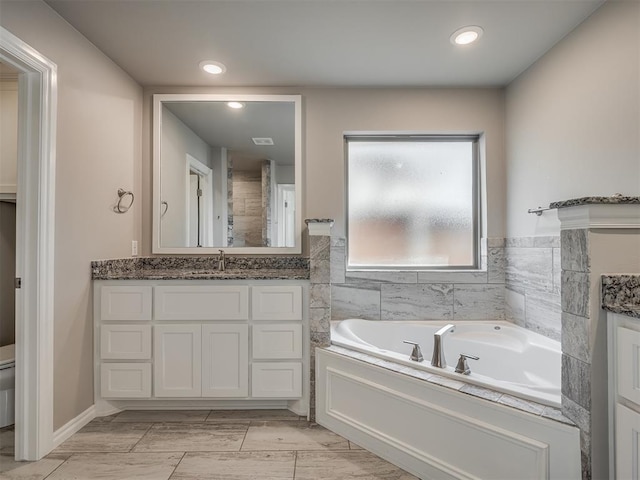 bathroom with vanity, toilet, and a bathtub