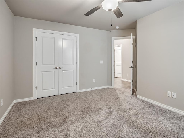 unfurnished bedroom featuring ceiling fan, a closet, and light carpet