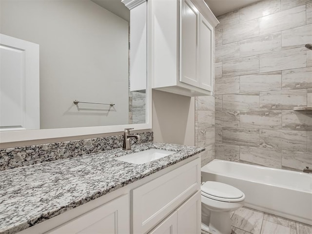 full bathroom featuring tiled shower / bath, vanity, and toilet