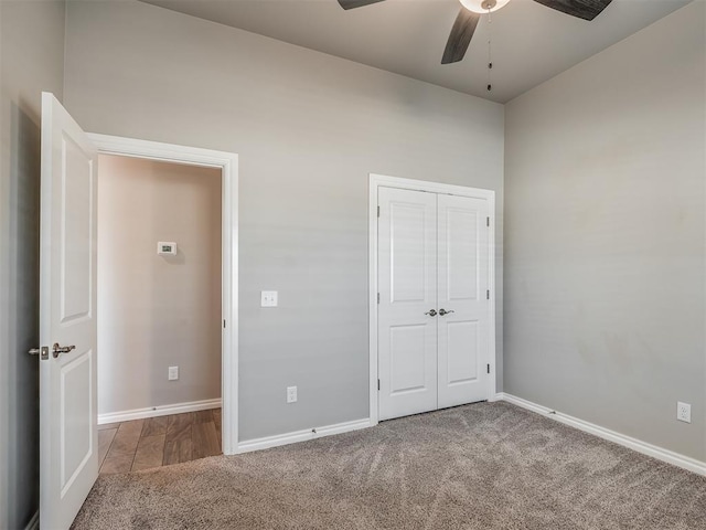 unfurnished bedroom featuring ceiling fan, light carpet, and a closet