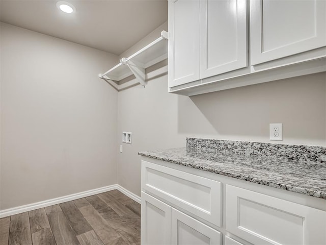 washroom featuring hardwood / wood-style floors, cabinets, and hookup for a washing machine