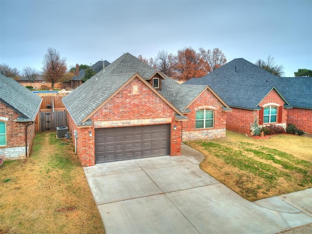 view of front of property with a garage, central air condition unit, and a front lawn