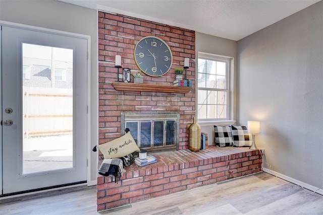 living room with a fireplace, light hardwood / wood-style floors, and a textured ceiling