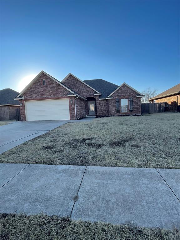 ranch-style house featuring a front yard and a garage