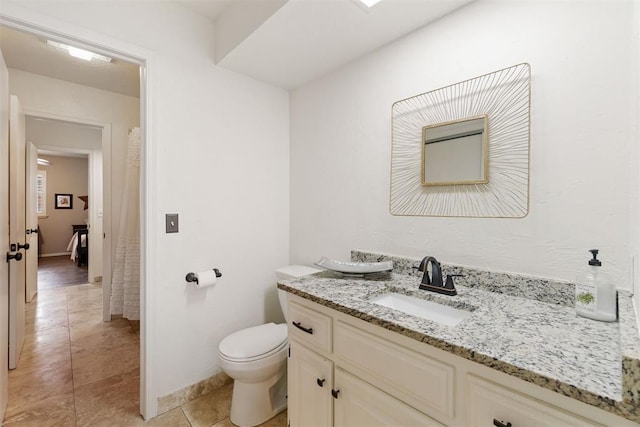 bathroom with toilet, vanity, and tile patterned floors