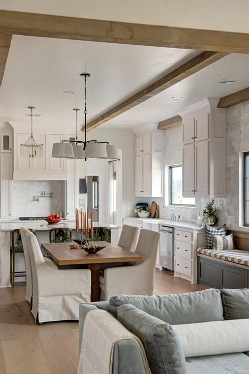 dining space with light hardwood / wood-style floors and beam ceiling