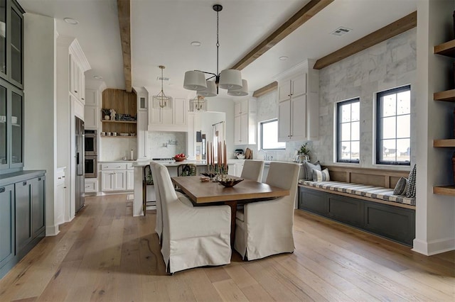 dining area featuring beam ceiling and light hardwood / wood-style floors