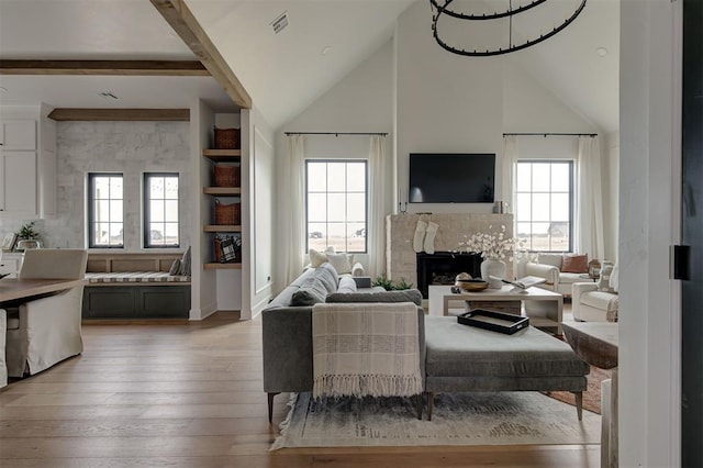 living room featuring light wood-type flooring, a wealth of natural light, and a fireplace