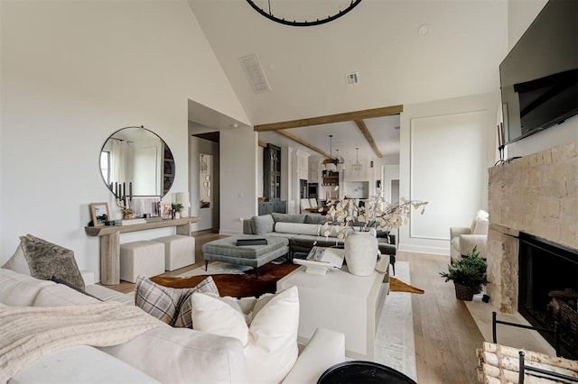 living room with high vaulted ceiling, light wood-type flooring, and beamed ceiling