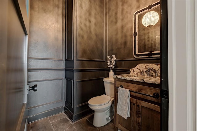 bathroom with toilet, vanity, a notable chandelier, and tile patterned flooring