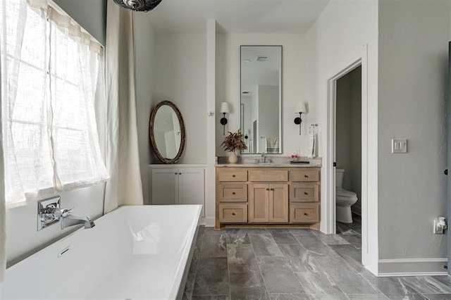 bathroom with toilet, vanity, and a bath