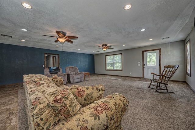 carpeted living room with a textured ceiling and ceiling fan