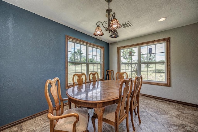 dining room featuring tile patterned flooring and a textured ceiling