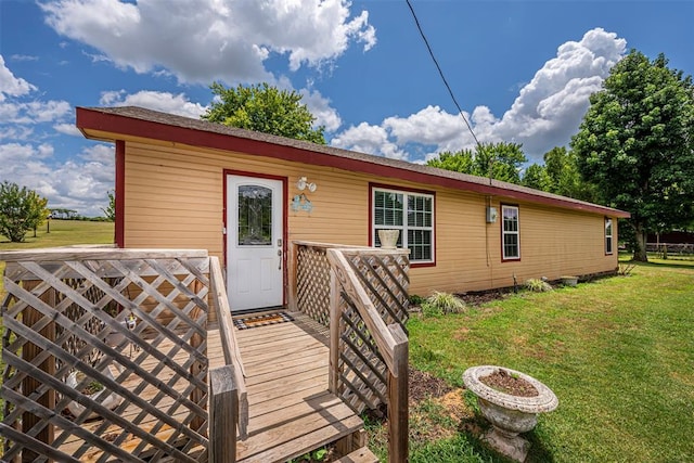 exterior space with a wooden deck and a front lawn