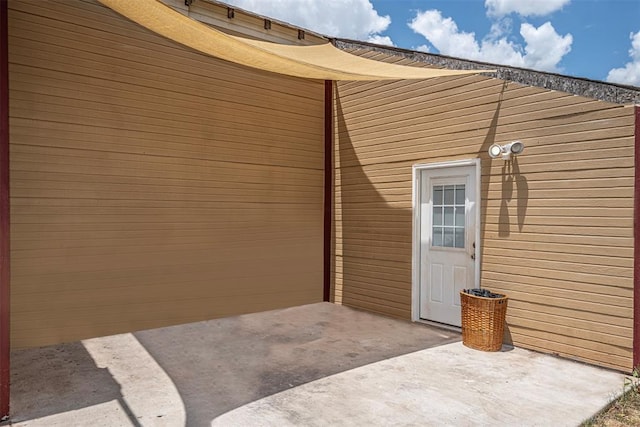 view of exterior entry with a patio