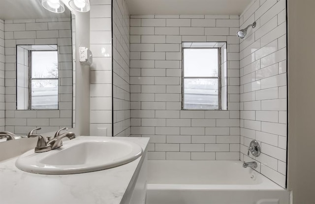 bathroom with tiled shower / bath combo and vanity