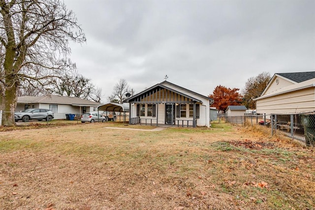 back of house with a carport and a yard